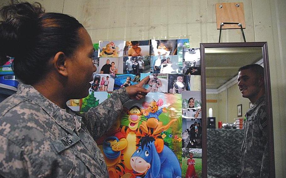 Pfc. Janie King points at a photo of her daughter, Saniya, as her husband and Saniya's father, Sgt. Christopher King, looks on. The Kings are currently on a 12-month deployment in Diyala as part of the 2nd Stryker Brigade Combat Team, 25th Infantry Division. They left Saniya with Christopher King's parents in Maryland. ''A lot of people say we are heroes for what we do,'' King, 25, wrote in an e-mail after becoming too emotional to talk about her daughter. ''But the heroes in my eyes are the grandparents or people who are providing for our children as if we never left.''