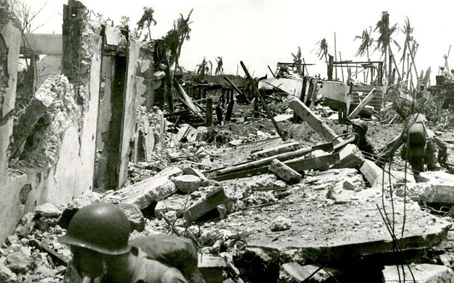 Marines advance through the ruins of Guam after a heavy U.S. bombardment in July 1944.