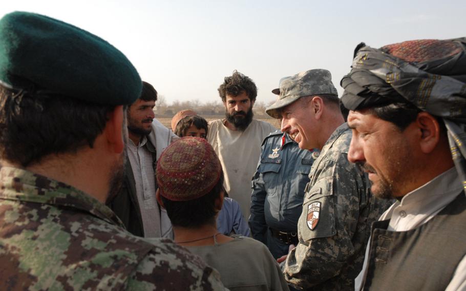 Gen. David Petraeus, commander of the International Security Assistance Force, talks with villagers about the commitments made to Afghanistan as he walked through a village on Monday that had been leveled by the U.S. military in its clearing campaign of the western side of Arghandab district. The Taliban had kicked out the residents of the village, rigged some of the houses to blow and turned the others into homemade bomb factories. The military is now rebuilding the village.