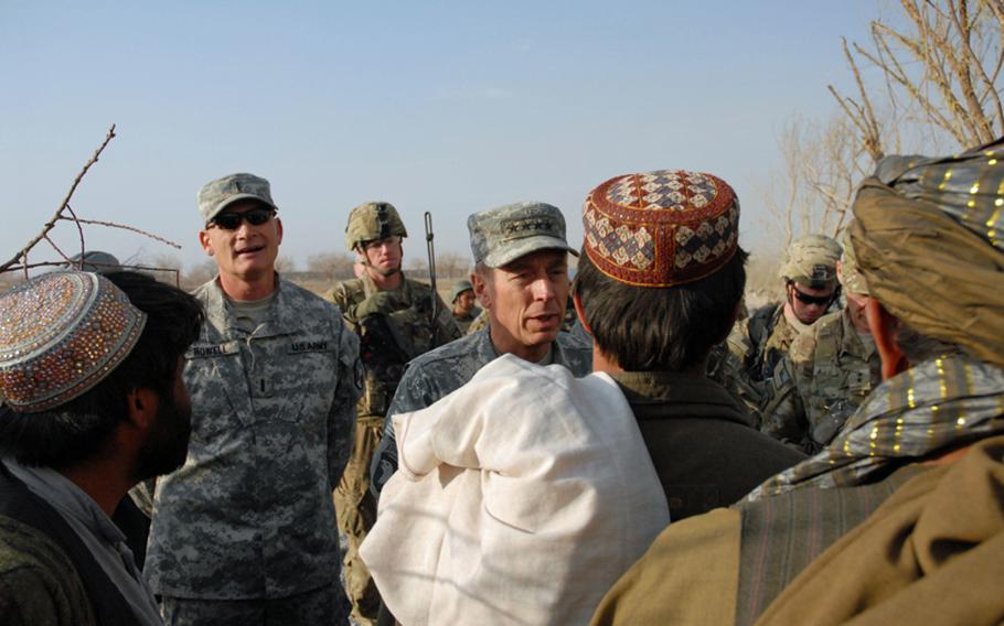 Gen. David Petraeus, commander of the International Security Assistance Force, talks with Afghans on Monday about their needs as he walked through their village. It had been leveled by the U.S. military in its clearing campaign of the western side of Arghandab district. The Taliban had kicked out the residents of the village, rigged some of the houses to blow and turned the others into homemade bomb factories. The military is now rebuilding the village.