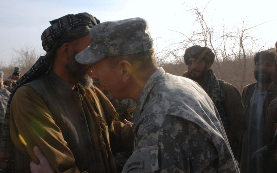 During a visit on Monday, Gen. David Petraeus, commander of the International Security Assistance Force, greets the malik of a village that had been leveled by the U.S. military in its clearing campaign of the western side of the Arghandab district. The Taliban had kicked out the residents of the village, rigged some of the houses to blow and turned the others into homemade bomb factories. The military is now rebuilding the village.
