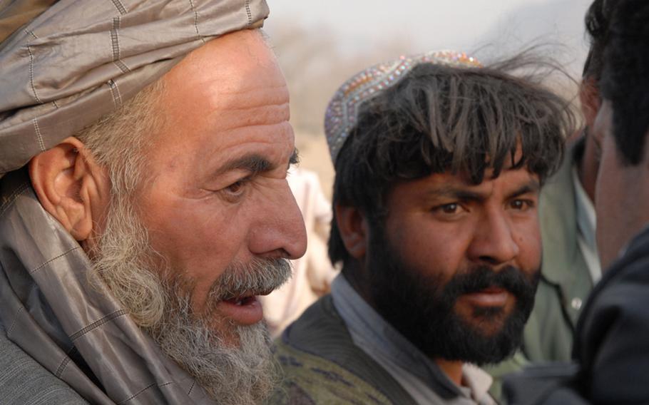 Residents of a village that had been destroyed during a clearing operation in the Arghandab district talk to Gen. David Petraeus through an interpreter Monday. The farmers questions the the top Afghanistan commander about whether the military, unlike in years past, would stick around.