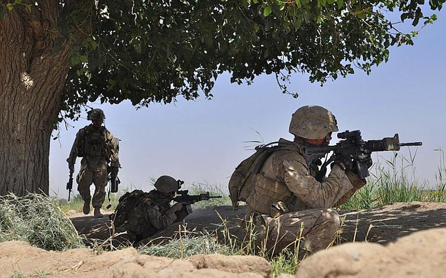 A Marine artilleryman walks to position during a gunfight with insurgents in Marjah on June 20. The insurgents fired across an open field from two buildings that Marines said were known IED locations.