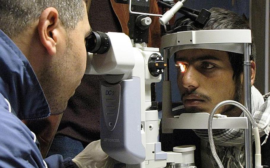 Dr. (Maj.) Hassam Mohamed of the Egyptian army, examines the eyes of Kamal, a 16-year-old local Afghan at the Egyptian Field Hospital at Bagram Air Field in Parwan province, north of Kabul.  Kamal suffered eye trauma in a motorcycle accident four years ago.