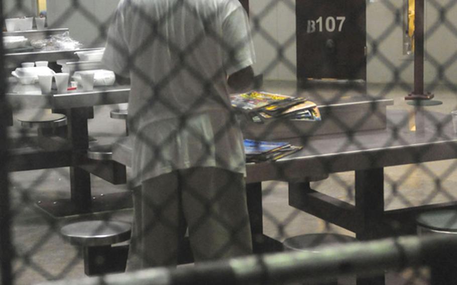 A Guantanamo detainee looks through a stack of magazines in this March 2010 photo. All detainees arriving at Guantanamo are administered a large dosage of the controversial anti-malarial drug mefloquine, regardless of whether they exhibit symptoms of the disease.