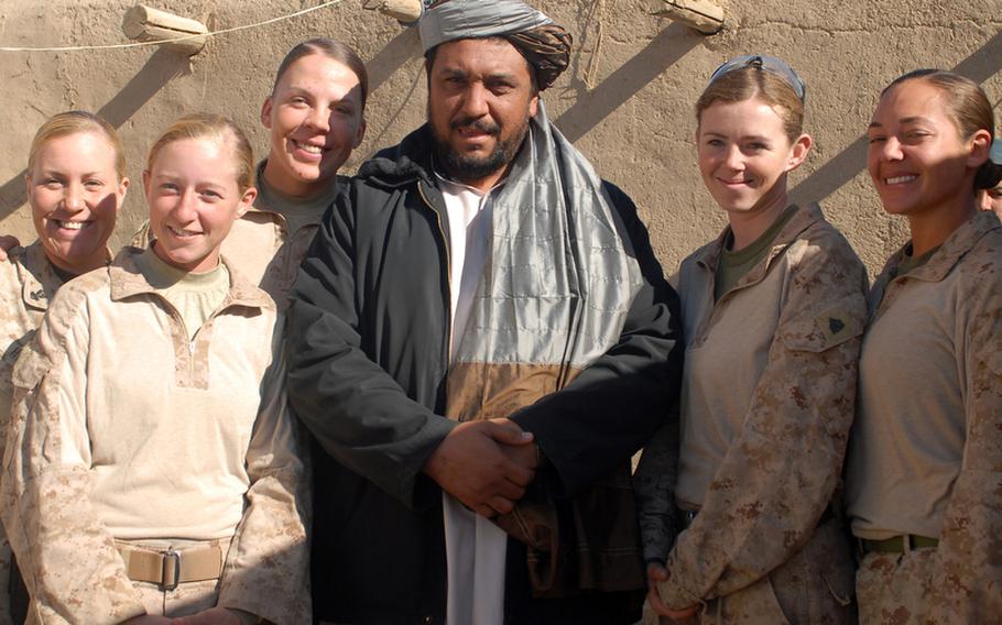 Among 17 FETs working in Helmand province to engage with Afghan women, who are prohibited from interacting with unrelated men or leaving their compound, are, from left, Navy corpsman HM2 Amy Housley, Cpl. Lakin Booker, Sgt. Brandy Perez, Sgt. Heather Evans and Sgt. Casey Littesy. They’re posing with Marjah district governor, Abdul Mutalab, at a gathering at a Marjah midwife’s house to provide local women with information about hygiene, pregnancy and child care.