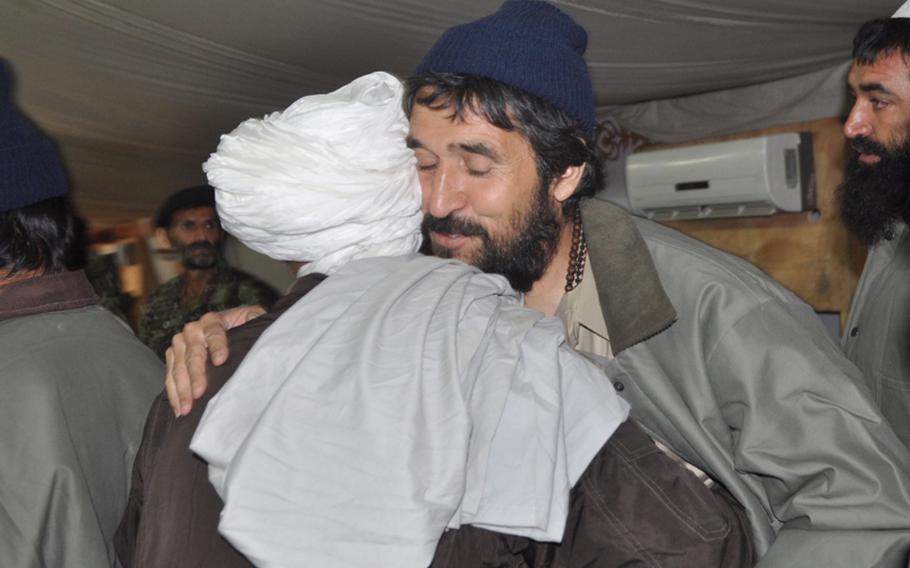 A released detainee at the U.S. Detention Facility in Parwan embraces an elder from his community at a release ceremony on Nov. 24.