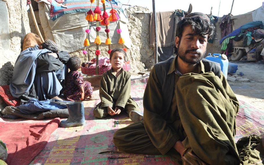 Hayat Khan, right, sits with his family at the Charah-e-Qambar camp for displaced people on the outskirts of the Afghan capital Kabul. Khan and his family fled violence in their home province Helmand.