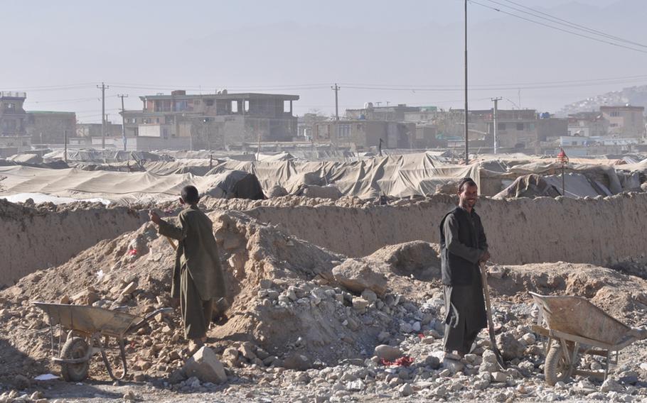 Residents bury trash outside of the Charah-e-Qambar displaced persons camp on the outskirts of Kabul  on Dec. 13. Most residents of the camp fled heavy fighting in the southern Helmand Province.