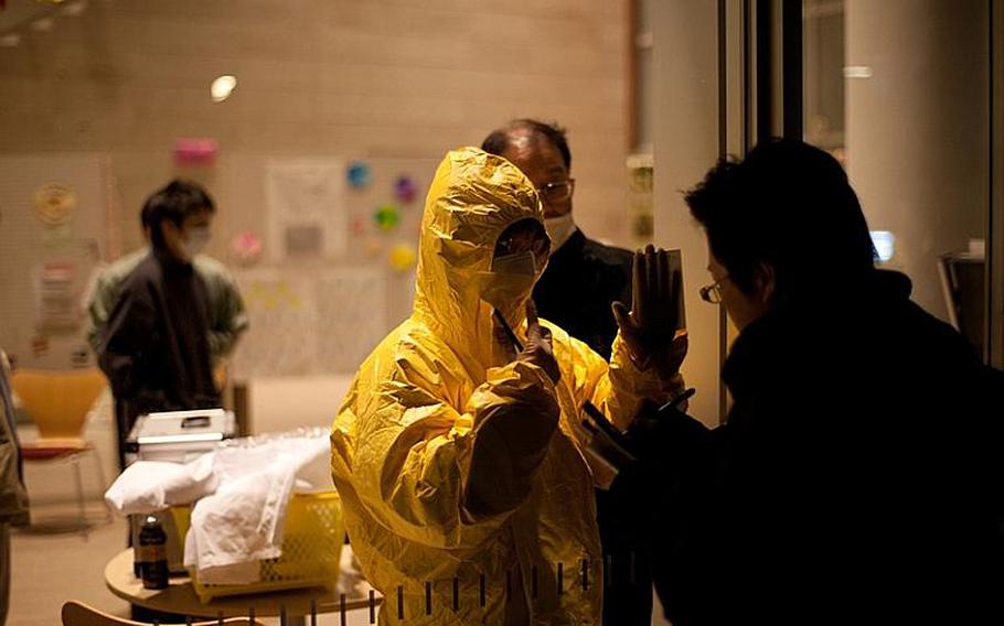 People evacuated from their homes near the nuclear power plant in Fukushima, Japan, soon after the March 2011 earthquake and tsunami are quarantined at a local community center awaiting radiation testing.