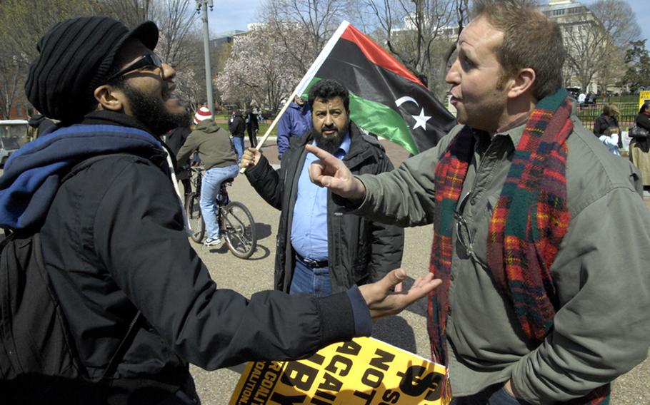 Joel Wallace, left, of Maryland, a participant in an ANSWER Coalition protest against the attacks on Libya, argues with Isam Elnaas of Ohio, who fled Libya 12 years ago and supports the effort to oust Moammar Gadhafi, Saturday afternoon in front of the White House.