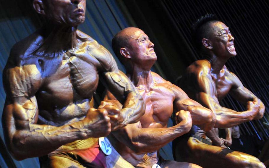 Men's masters competitors Hidekazu Taba, Mitsuhiro Gima and Takashi Omine pose down during Sunday's 5th Pacific Muscle Classic bodybuilding, fitness and figure competition at Keystone Theater, Kadena Air Base, Okinawa. Taba won the men's masters title.