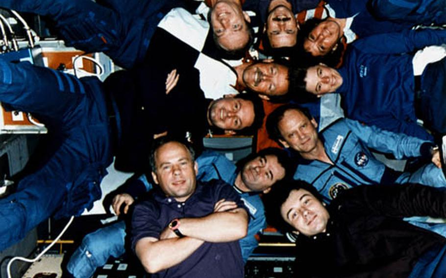 Inside the Spacelab Science Module, the crews of STS-71, Mir-18 and Mir-19 pose for the traditional inflight picture.