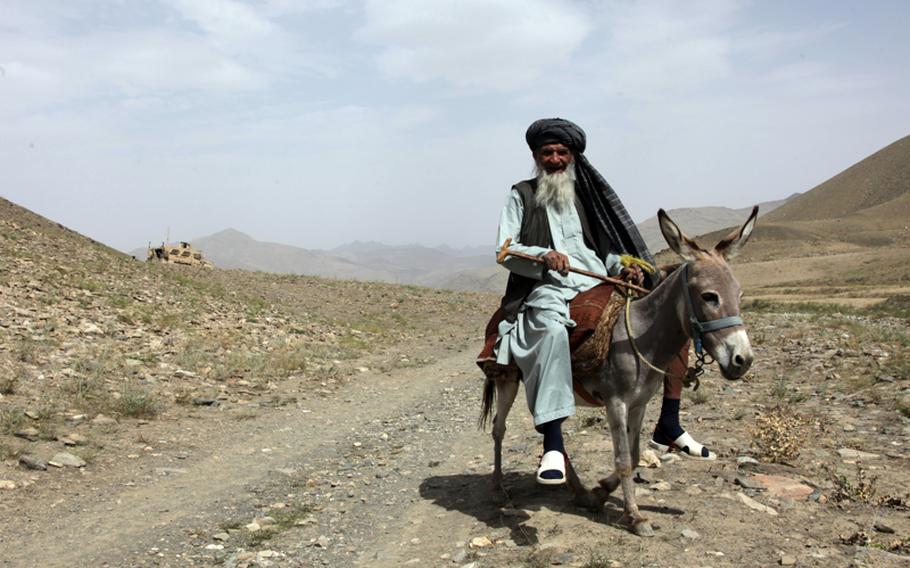 An Afghan man rides his donkey while on his way into the village of Syahchob, Wardak province, Afghanistan, in 2010. The gallows humor of war had some U.S. soldiers in Wardak shaking their heads at rumors of a donkey-borne improvised explosive device, or "DBIED."