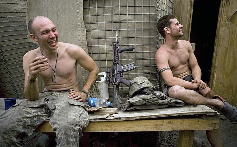 Specialist Misha Pemble-Belkin, left, and Ross Murphy of Battle Company, 173rd U.S. Airborne Brigade share a laugh at Outpost Restrepo in Korengal Valley, Afghanistan in 2008. 