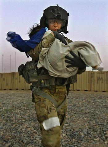 Flight medic Cpl. Amanda Mosher, of the 563rd Aviation Support Battalion, 159th Combat Aviation Brigade, 101st Airborne Division carries an Afghan baby to a medevac helicopter at Combat Outpost Nalgham on June 15, 2011, in Kandahar province, Afghanistan. The baby had been severely burned by boiling water and was brought to the COP by her father for treatment.
