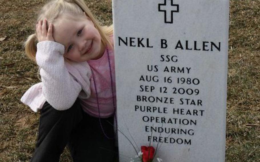 Staff Sgt. Nekl Allen's daughter, Grace, poses with his headstone at Arlington National Cemetery in February 2010. Allen was killed on Sept. 12, 2009, when a bomb exploded beneath his MRAP in Afghanistan.