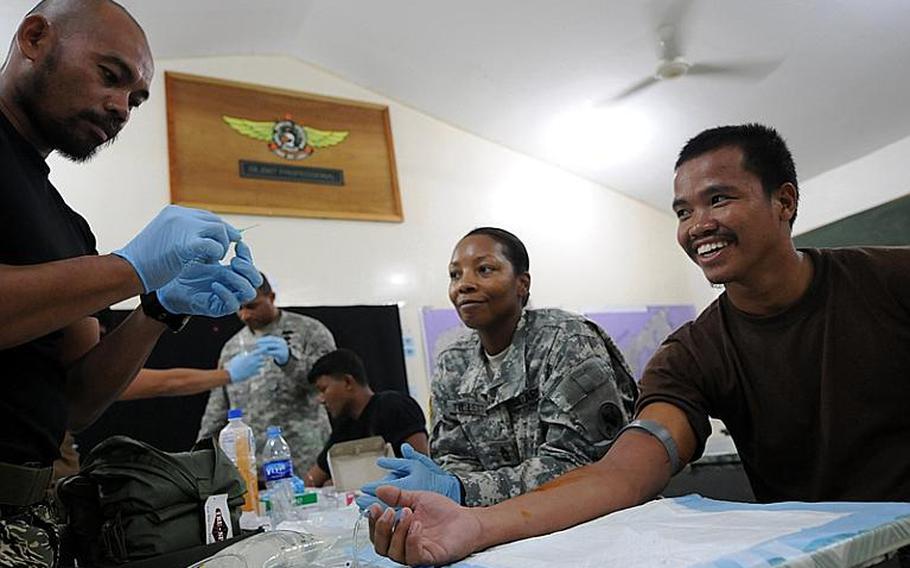 Members of Naval Special Operations Unit (NAVSOU) 6 practice setting up an IV (intravenous) line during a Combat Lifesaver Course held with Joint Special Operations Task Force - Philippines (JSOTF-P). The Combat Lifesaver Course is designed to teach nonmedical soldiers how to provide lifesaving measures as a secondary mission as their primary (combat) mission allows.