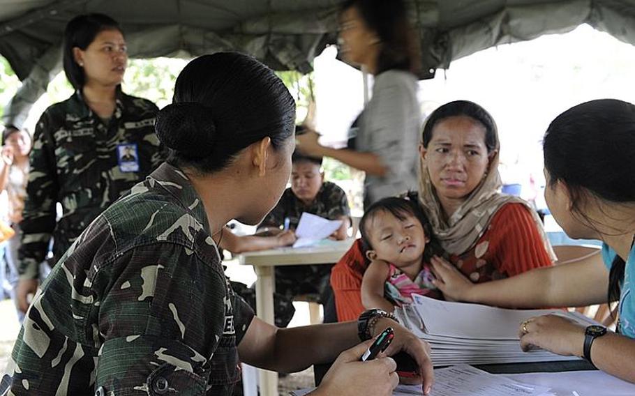 Armed Forces of the Philippines (AFP) nurses help with patient inprocessing of children waiting for cleft lip and cleft palate surgery at Camp Siongco Station in Maguindanao. The AFP&#39;s 6th Infantry Division in Maguindanao partnered with Joint Special Operations Task Force-Philippines (JSOTF-P), Knightsbridge International, Autonomous Region of Muslim Mindanao (ARMM) Department of Health, ARMM Department of Social Welfare and Development and local volunteer nurses to bring the non-governmental organization Operation Smile into the ARMM for the first time, and conduct close to 100 surgeries in four days.