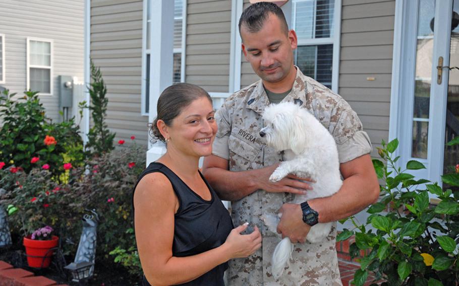 Sandra and Felix Rivera outside their Hubert, N.C., home in September. Felix holds his dog, Gizmo, who the Marine jokes is like his therapy dog. The couple struggled to hold onto their marriage after Felix was injured in 2009 and came home suffering from post-traumatic stress disorder and traumatic brain injury.