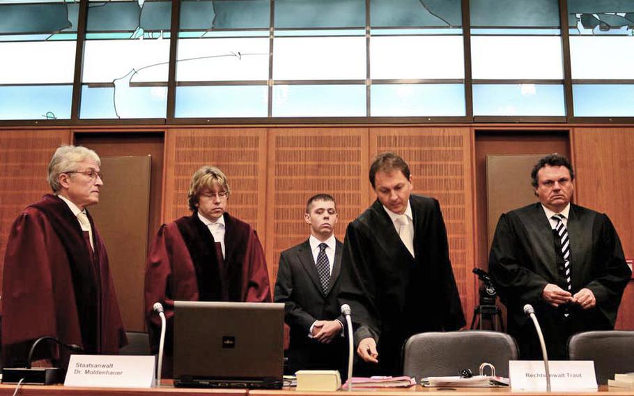 German prosecutors filed the most severe murder charge against Arid Uka, who has admitted to killing two U.S. airmen and trying to kill three more at the Frankfurt International Airport on March 2. Pictured from left are two prosecutors (in red robes), Air Force Staff Sgt. Trevor Brewer, who testified Uka tried to shoot him twice, Marcus Traut, the lawyer representing Brewer and the two wounded airmen, and Marcus Steffel, representing the families of the dead airmen. 