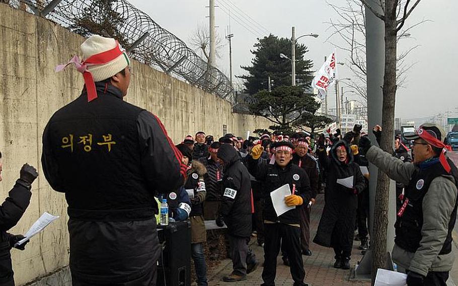 South Koreans chant outside U.S. Army Garrison - Red Cloud in December 2011 to protest a plan to lay off hundreds of workers. The union representing local workers is now threatening to go on strike if full-time employees go to a part-time status.