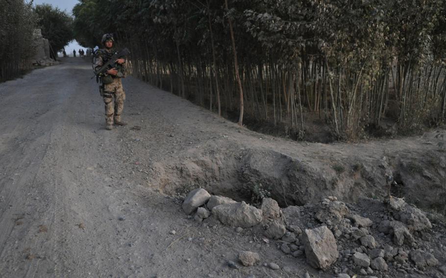 A crater created by a roadside bomb scars the earth along Route Cherry, one of the main roads in the Char Dara district, southwest of the city of Kunduz, Afghanistan. German troops have been hit with improvised explosive devices several times along Cherry. A German captain was killed in one attack in 2011.