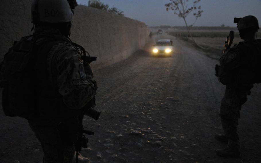 A car approaches German troops during a patrol at dusk in the Char Dara district, Kunduz province, Afghanistan.