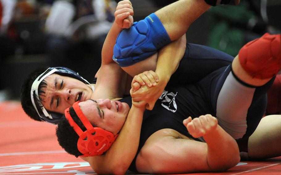 Menwith Hill's Chris Milam, rear, has a grip on Bitburg's Ian Keller during their 152-pound match in Kaiserslautern  on Saturday. Milam won with a 10-6 decision.
