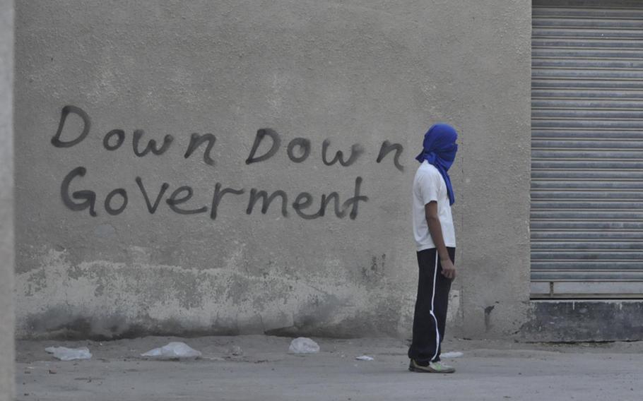 A teenage boy waits for police and the inevitable launch of tear gas Dec. 22 during a protest in Bahrain&#39;s Abu Seba village. Bahrain&#39;s ruling regime, a longtime U.S ally and host to the Navy&#39;s 5th Fleet, have been slow to implement democratic reform since the unrest began in February.
