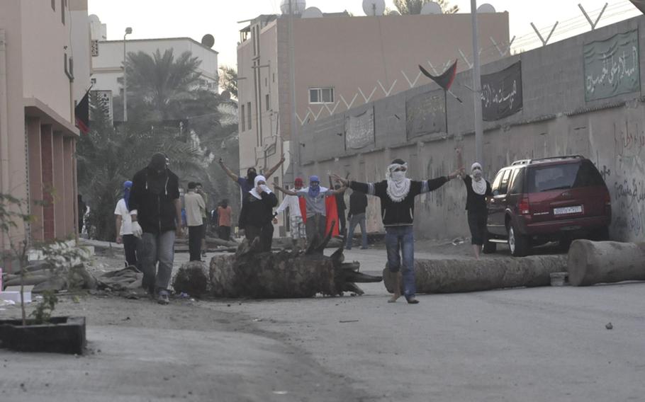 Protesters surround a homemade barricade Dec. 22 in the Abu Seba village of Bahrain. Among other tactics, protesters say the police have been known to run down protesters.