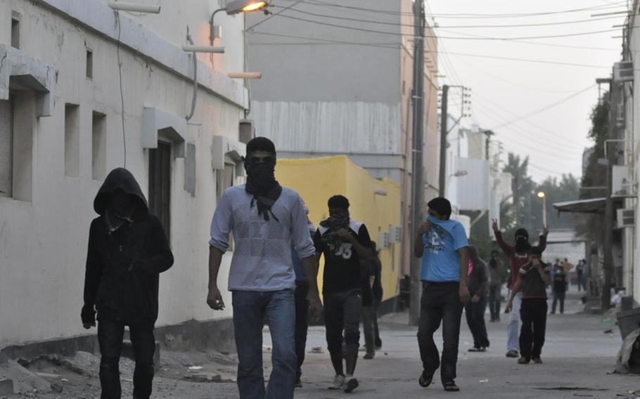 Protesters move away from a police tear gas cloud during a protest Dec. 22 in Bahrain&#39;s Abu Seba village.