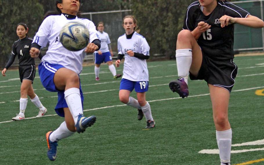 Seoul American's Ivy Dela Cruz fields the ball against Seoul Foreign's Sarah Stegner during Friday's Korean-American Interscholastic Activities Council girls Division I soccer match at Yongsan Garrison, South Korea. The visiting Crusaders blanked the Falcons 3-0.