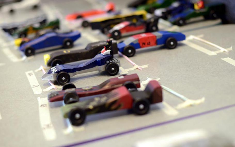 Some of the pinewood derby race cars, built by Barbarossa District Cub Scouts and their parents, wait for their turn to race in the district pinewood derby championships Saturday afternoon at the KMCC on Ramstein Air Base, Germany.