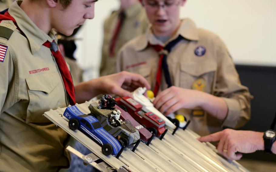 Barbarossa District Boy Scouts manage the pinewood derby race cars during the Barbarossa District Cub Scouts pinewood derby championships Saturday afternoon at the KMCC on Ramstein Air Base, Germany.