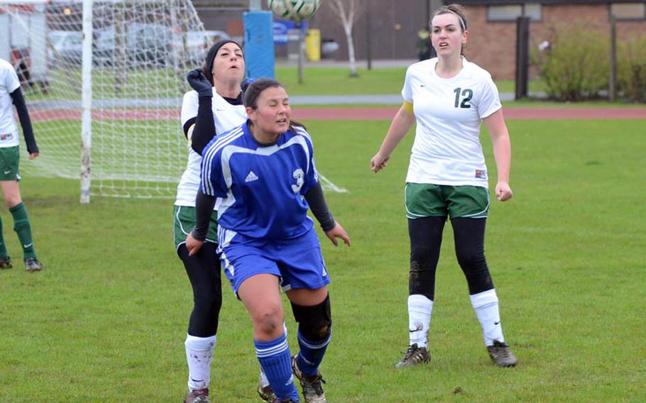 Brussels' Alexandra McVicker, foreground, prepares to head the soccer ball as defenders Nichole Pisierra, left, and Chelsea DeWitt try to disrupt the play, Saturday, at RAF Alconbury, England. McVicker scored three of the Brigands' four goals during their shutout of the Dragons.