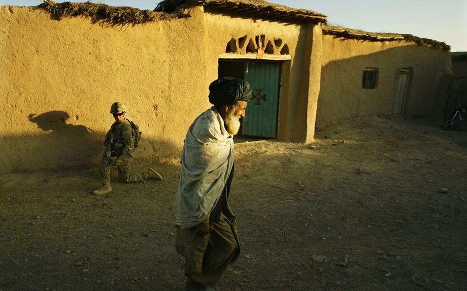 Pfc. Brian Silva, of Company F, 4th Battalion, 101st Aviation Regiment, 159th Combat Aviation Brigade, 101st Airborne Division, kneels  while patrolling the village of Loy Shur with Afghan National Army soldiers on Sept. 23, 2011, in Zabul province, Afghanistan.