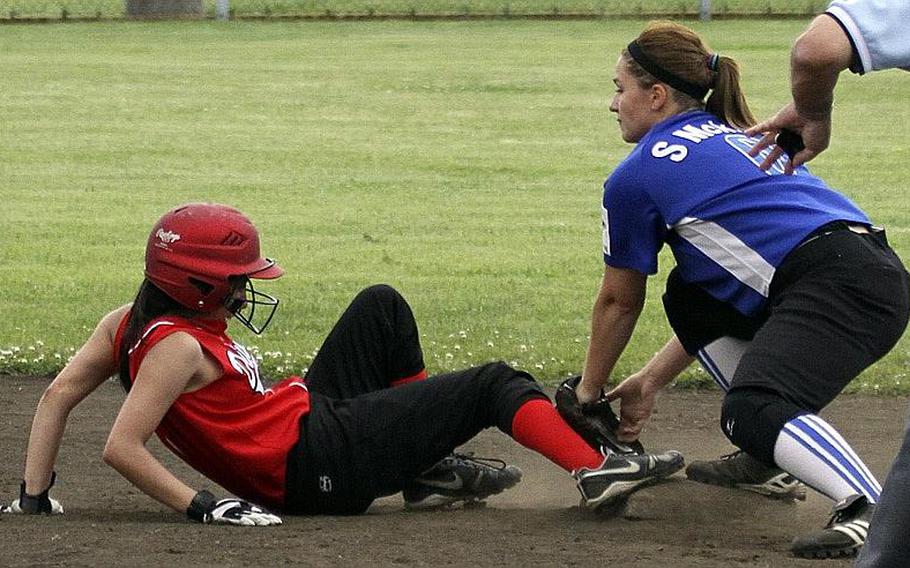 Nile C. Kinnick's Elizabeth Farrelly slides back into second base safely ahead of the tag of Seoul American shortstop Sheridan McKitrick during Monday's pool-play game in the Far East High School Girls Division I Softball Tournament at Naval Air Facility Atsugi, Japan. The Red Devils pounded the defending tournament champion Falcons 18-2.
