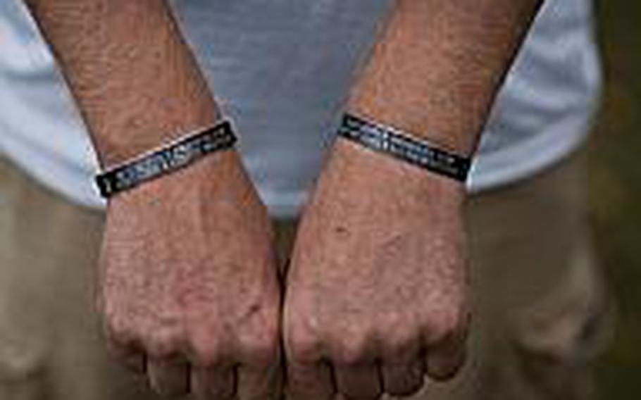 Medal of Honor recipient Dakota Meyer shows the black wristbands he wears on each arm honoring the three Marines and Navy corpsman who were killed in action in Ganjgal, Afghanistan, Sept. 8, 2009.