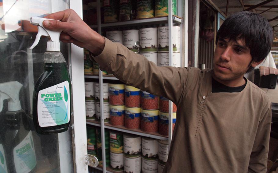 An Afghan shop worker holds up a bottle of Power Green, a cleaner made by the National Industries for the Blind, an American organization that makes products under the trade name "Skilcraft" for U.S. government agencies, including the Defense Department. Skilcraft and other American products are sold in Kabul&#39;s "Bush Market," which specializes in goods apparently stolen from American supply convoys.