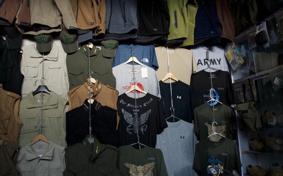American-brand clothing, including U.S. Navy and Army T-shirts, lines the walls of a shop in Kabul’s “Bush Market,” which specializes in goods apparently stolen from American supply convoys.