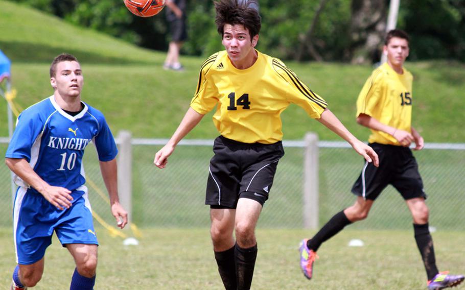 Jeremiah Ishikawa of Kadena heads the ball away from Ryan Hollands of Christian Academy Japan during Tuesday's pool-play match in the Far East High School Boys Division I Soccer Tournament at Camp Foster, Okinawa. The Knights blanked the Dragons 1-0.