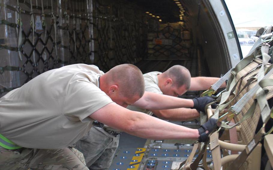 Airmen unload a FedEx DC-10 cargo plane at Bagram Air Field, Afghanistan, on May 13, 2012. The Air Force frequently uses the cheaper commercial carriers for routine supply delivery, reserving military "gray tails" for large, dangerous or sensitive items.