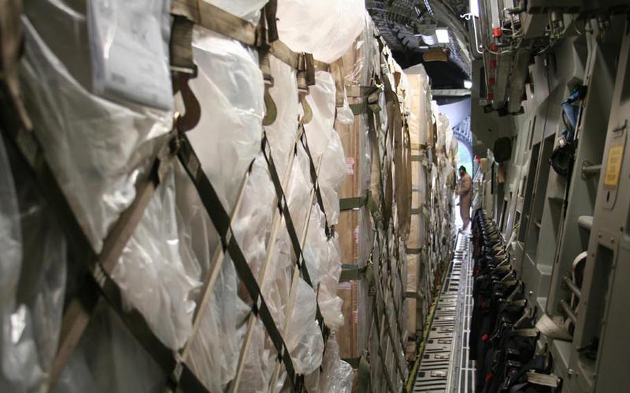 A loadmaster guides a pallet of explosives into the rear of a packed C-17 cargo compartment at Bagram Air Field, Afghanistan, on May 18, 2012.