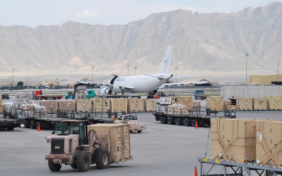 A front-end loader unloads a commercial cargo plane in Afghanistan at Bagram Air Field's bustling aerial cargo port on May 13, 2012.