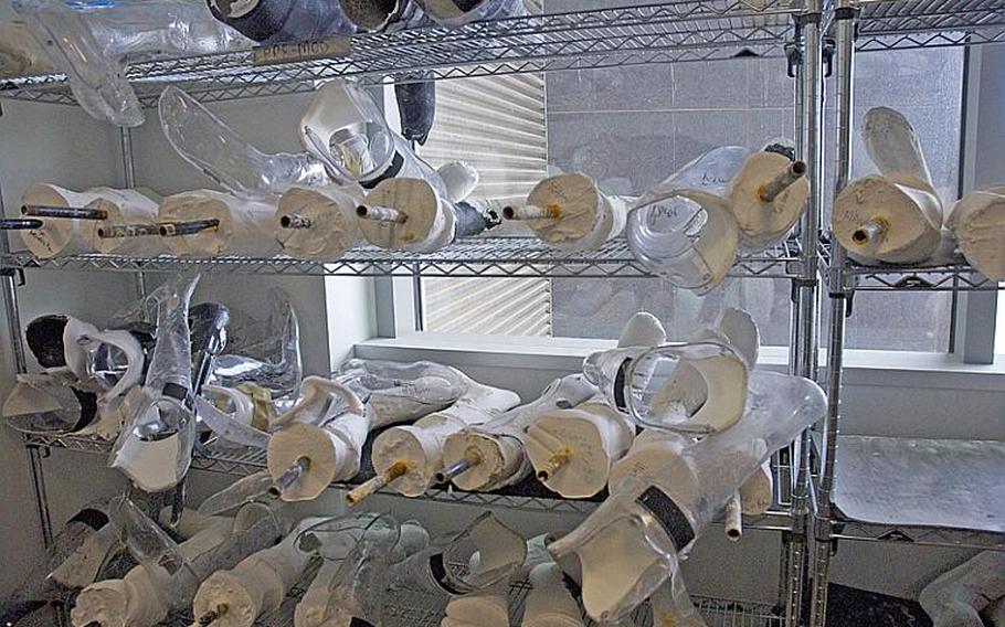 Molds of patients&#39; legs are stacked in the crammed workspace at the Center for the Intrepid at Brooke Army Medical Center. They&#39;ll eventually be used to create custom prosthetic-like devices for service members who have badly injured legs - once the overwhelmed team has a chance to get to them.