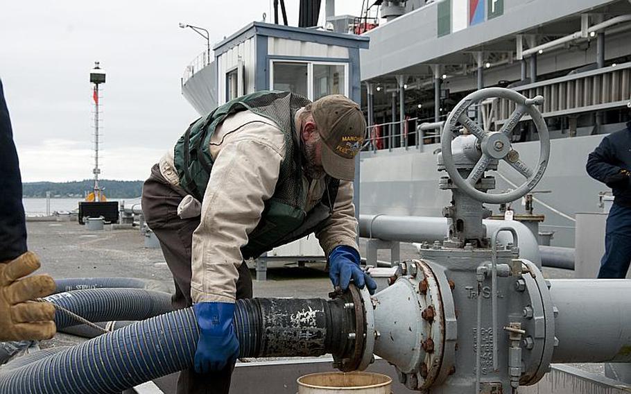 David Riggs, from Fleet Logistic Center Puget Sound, Wash., secures a fueling hose during a biofuel transfer to the USNS Henry J. Kaiser on July 13, 2012. The ship took on 900,000 gallons of a 50/50 blend of biofuels and petroleum-based fuel, and is now fueling ships participating in the Great Green Fleet demonstration during the Rim of the Pacific exercise in Hawaii. 