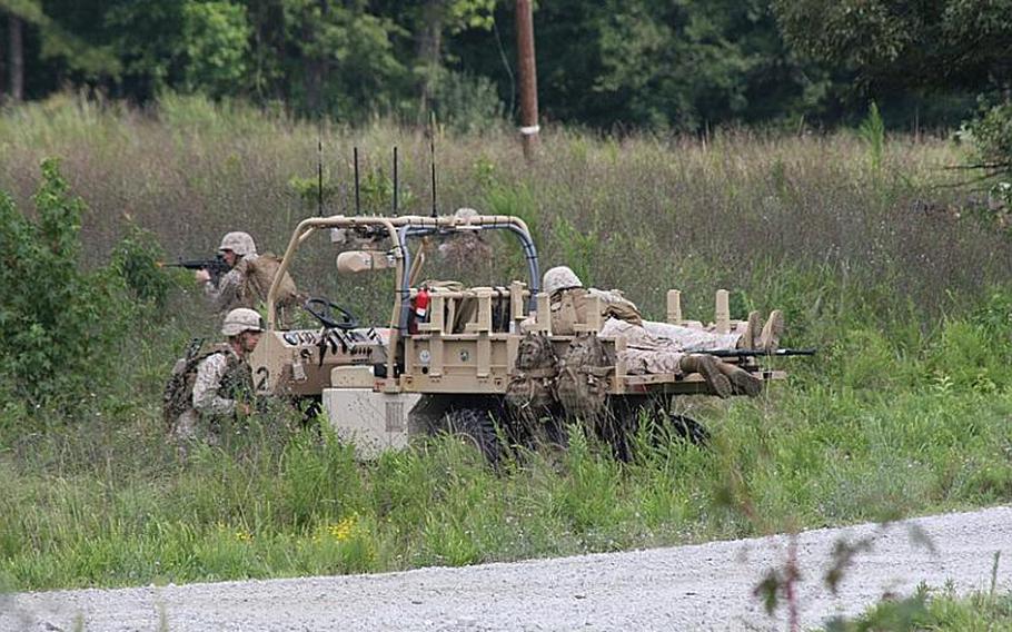 Marines load a "casualty" into the back of GUSS, an autonomous robot designed to carry loads for squads on patrol during a demonstration at Fort Pickett, Va., on July 30, 2012.