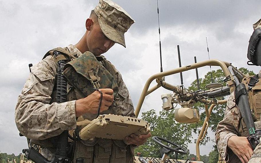 Lance Cpl. David Barrientos demonstrates a control pad for the GUSS robot at Fort Pickett on July 30, 2012. GUSS operates autonomously but can be switched to manual control if it encounters problems.