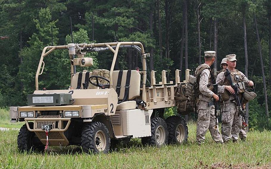 Marines with the GUSS, an autonomous robot designed to carry loads for squads on patrol during a demonstration at Fort Pickett, Va., on July 30, 2012.
